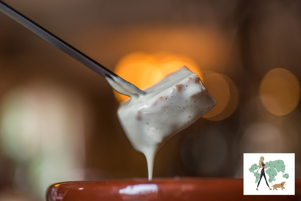 garfo espetado em pão molhado com fondue de queijo