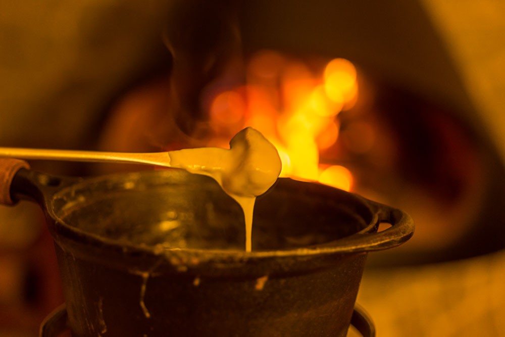 fondue de queijo com lareira ao fundo