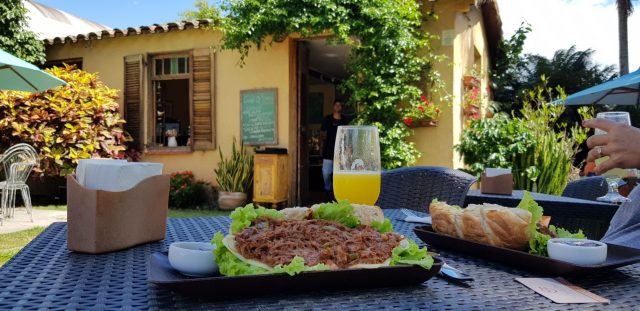 Café e Prosa: charme de cafeteria pet friendly em Porto Alegre mesa com sanduíche e suco de laranja