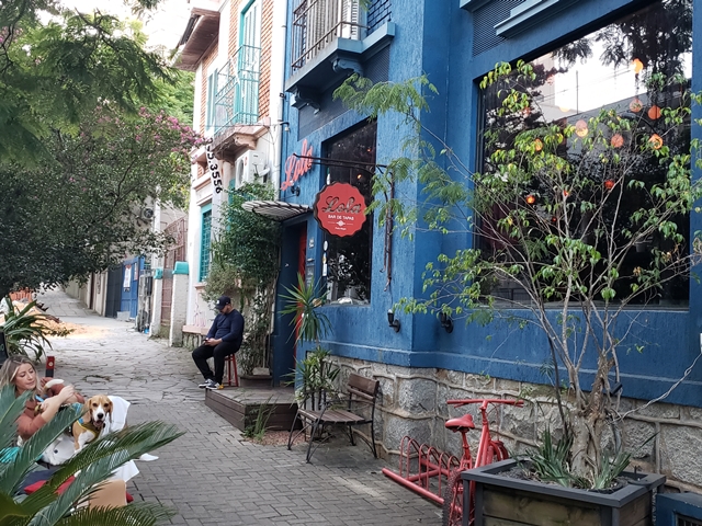 fachada azul do restaurante, mulher e cachorro sentados