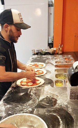 homem fazendo pizzas