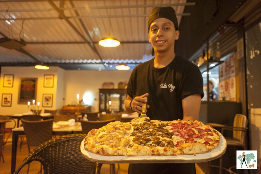 homem segurando pizza